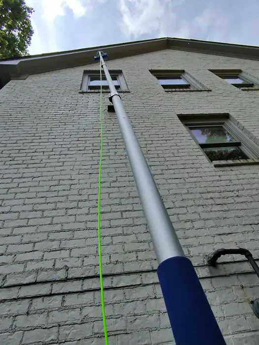 Step 2, Rinse: Water fed pole reaching third floor windows on a brick home